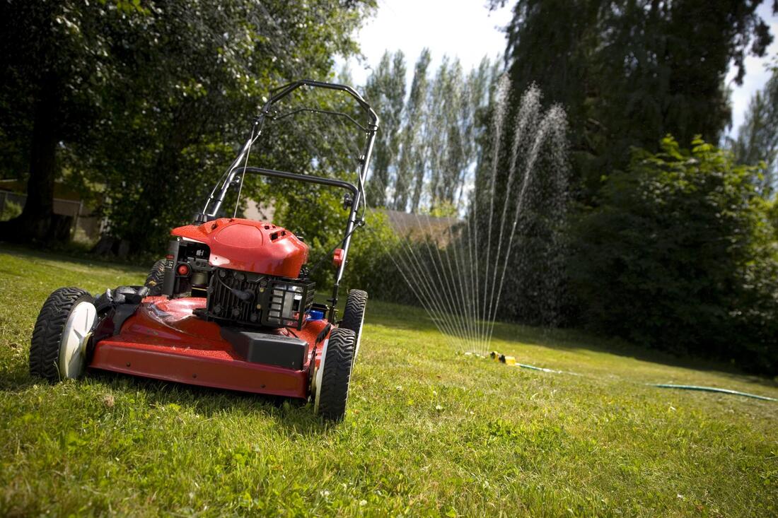 a mowing machine and a sprinkler on the lawn